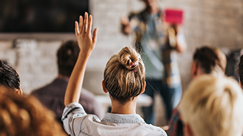 woman-in-classroom-raising-hand