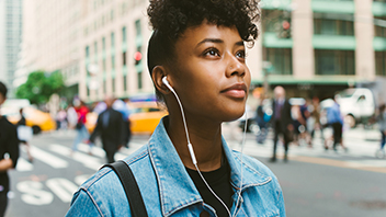 woman-walking-in-the-street-with-earphones